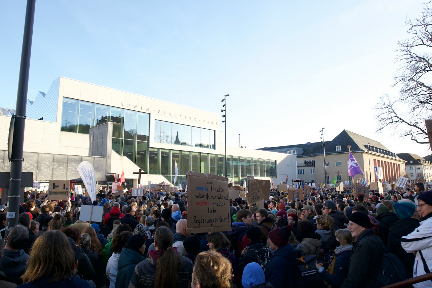 Persone con cartelli a una manifestazione pubblica fuori dall'Erwin-Piscator-Haus.